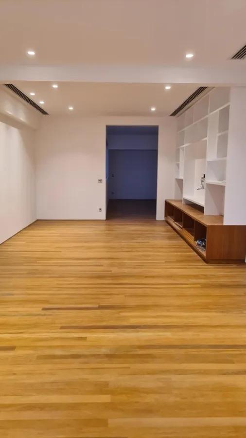 Apartamento com piso de madeira — sala estante. Obra da Alta Construtora.