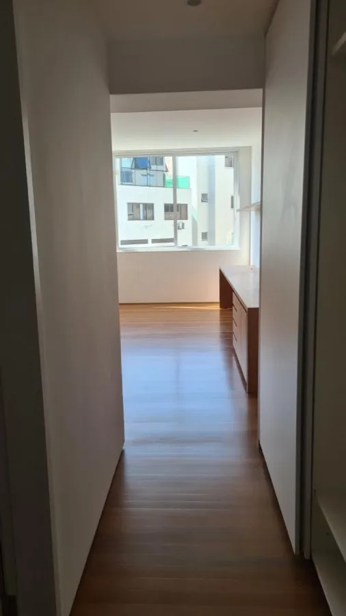 Apartamento com piso de madeira — corredor quarto. Obra da Alta Construtora.