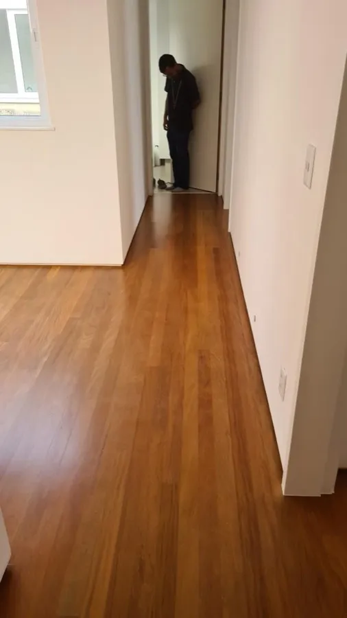 Apartamento com piso de madeira — corredor obra. Obra da Alta Construtora.