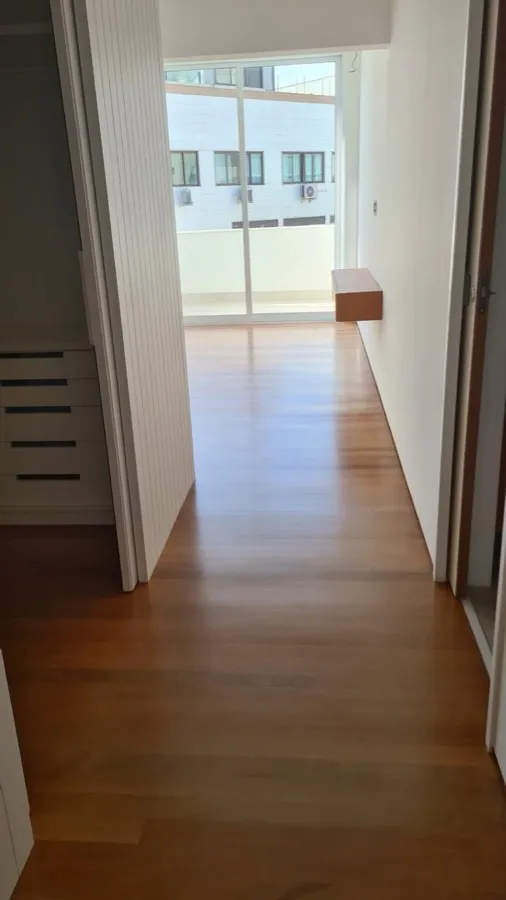 Apartamento com piso de madeira — corredor closet. Obra da Alta Construtora.