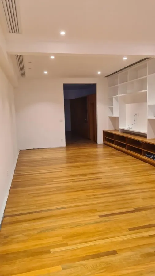Apartamento com piso de madeira — sala estante marcenaria. Obra da Alta Construtora.