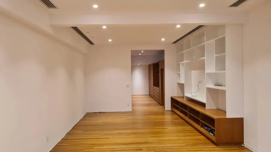 Apartamento com piso de madeira — sala estante ampla. Obra da Alta Construtora.