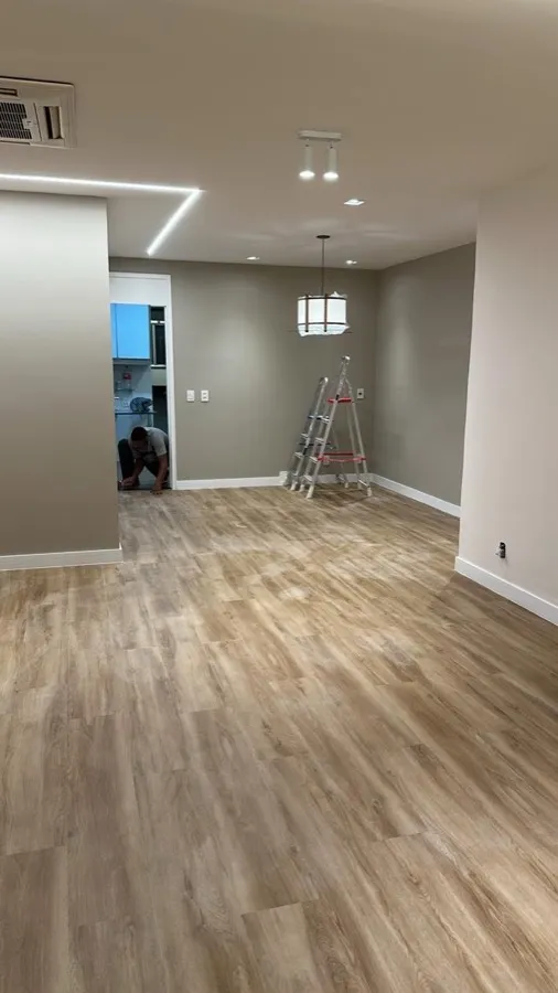 Apartamento com piso vinílico — sala. Obra da Alta Construtora.