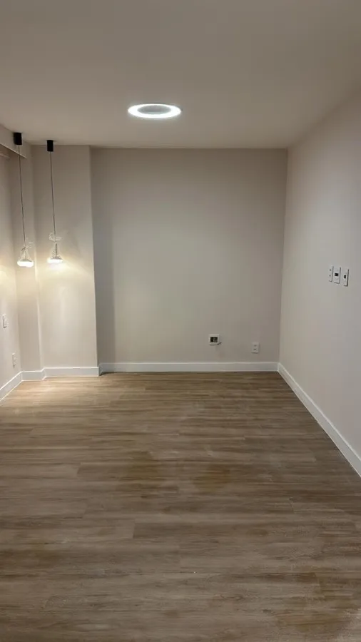Apartamento com piso vinílico — quarto luminária. Obra da Alta Construtora.