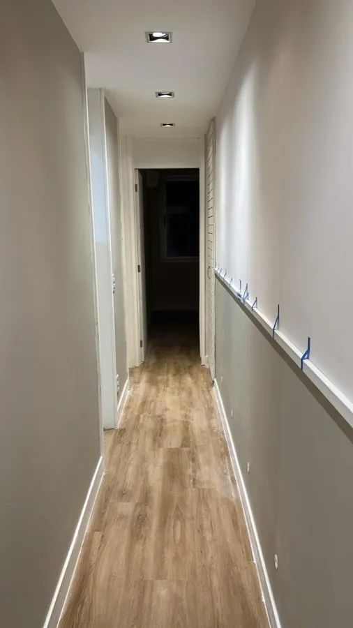Apartamento com piso vinílico — corredor. Obra da Alta Construtora.