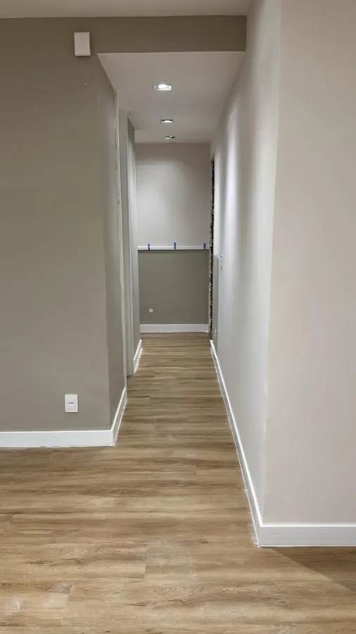 Apartamento com piso vinílico — corredor entrada. Obra da Alta Construtora.