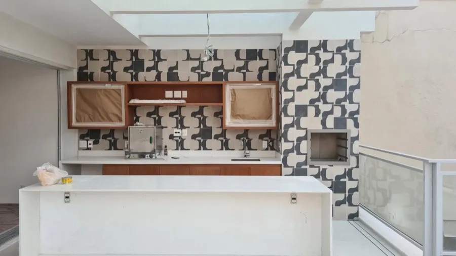 Cobertura com área gourmet — bancada azulejo geométrico. Obra da Alta Construtora.