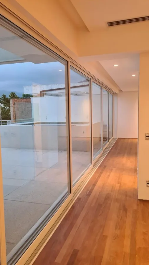 Cobertura com área gourmet — corredor envidracado. Obra da Alta Construtora.